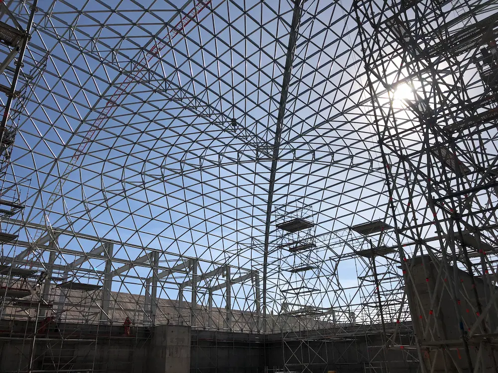 Estructura interior del domo industrial de Spence con marco espacial de acero Triodetic, mostrando ensamblaje, andamios y uniones estructurales.